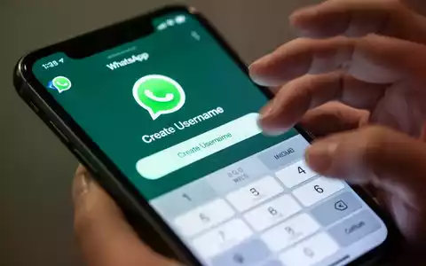 Nahaufnahme eines iPhone-Bildschirms mit der WhatsApp-App und der neuen 'Benutzernamen erstellen'-Funktion. Eine Hand interagiert mit dem Bildschirm. - Foto: über boerse-global.de