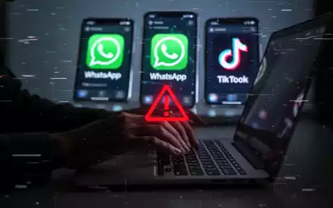 Hände tippen auf Laptop, Smartphone-Bildschirme mit WhatsApp- und TikTok-Symbolen und digitalen Störungen, die Malware darstellen. - Foto: über boerse-global.de