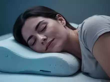 Eine Person schläft friedlich auf einem ergonomischen Kissen, das Kopf und Nacken stützt. Sanftes Licht beleuchtet die Szene. - Foto: über boerse-global.de