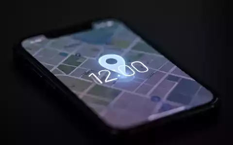 Ein Smartphone-Bildschirm mit einem unscharfen Karten- oder Standortsymbol und einer digitalen Uhr, die 12:00 anzeigt. - Foto: über boerse-global.de