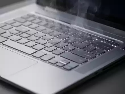 Nahaufnahme einer silbernen Laptop-Tastatur mit leichtem Hitzeflimmern über den Lüftungsschlitzen, das Kühlungsprobleme symbolisiert. - Foto: über boerse-global.de