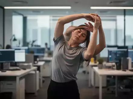 Eine Person macht Dehnübungen im Büro, um die Körperhaltung zu verbessern und Verspannungen vorzubeugen. - Foto: über boerse-global.de