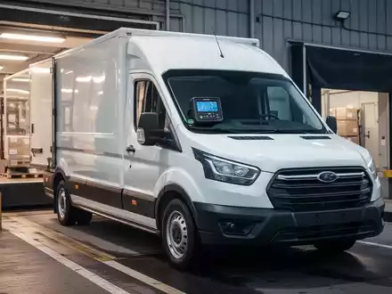 Ein weißer Transporter mit einem digitalen Tachografen auf dem Armaturenbrett, geparkt an einer Laderampe. - Foto: über boerse-global.de