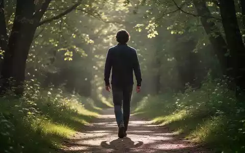 Eine Person geht auf einem Waldweg, Sonnenlicht fällt durch die Bäume. Fokus auf Bewegung und die Verbindung zur Natur. - Foto: über boerse-global.de