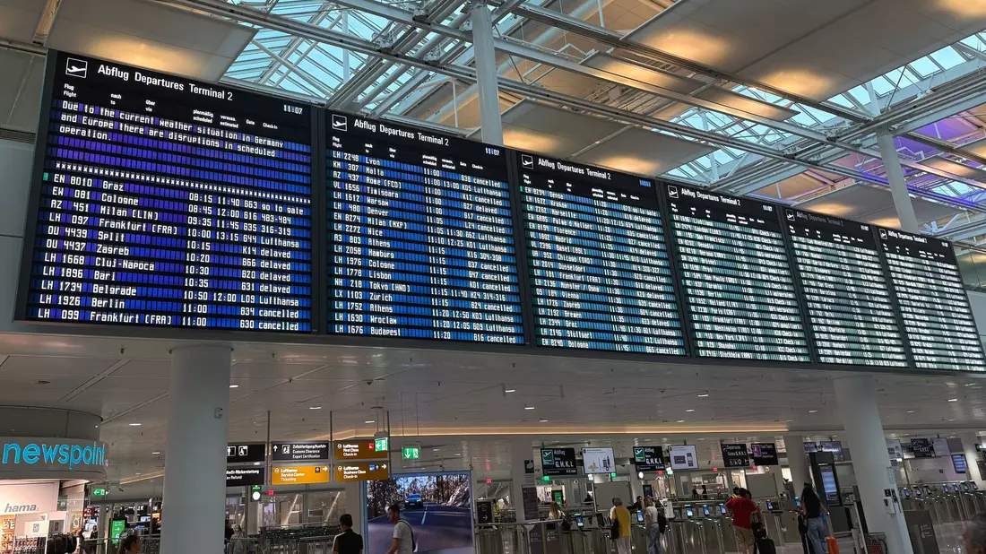 Auf einer Anzeigetafel am Flughafen war von witterungsbedingten Einschränkungen die Rede. - Bild: Manuel Schwarz/dpa