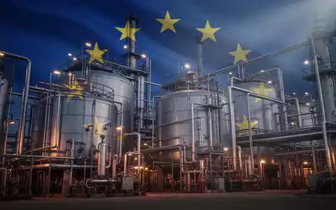 Eine stilisierte Chemieanlage mit großen Industriebehältern und komplexen Rohrleitungen unter dramatischem Licht, im Hintergrund die EU-Flagge. - Foto: über boerse-global.de