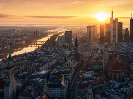 Münchner Bürotürme und Kirchtürme bei goldenem Sonnenaufgang im Stadtzentrum. Munich Re, ISIN DE0008430026 - Foto: THN