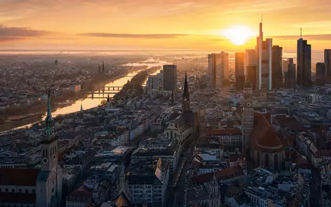 Münchner Bürotürme und Kirchtürme bei goldenem Sonnenaufgang im Stadtzentrum. Munich Re, ISIN DE0008430026 - Foto: THN