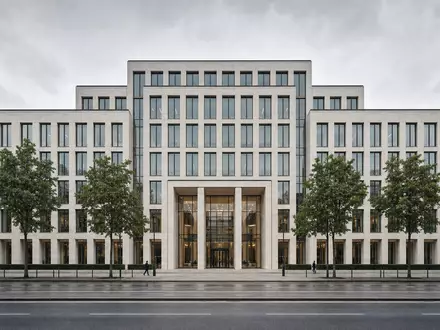 Repräsentatives Münchner Bürogebäude mit heller Steinfassade und Stadtbäumen. Munich Re, ISIN DE0008430026 - Foto: THN