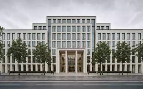 Repräsentatives Münchner Bürogebäude mit heller Steinfassade und Stadtbäumen. Munich Re, ISIN DE0008430026 - Foto: THN