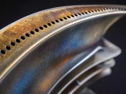 Extreme Makro-Nahaufnahme einer Titan-Turbinenschaufel mit Kühllöchern. MTU Aero Engines AG, ISIN DE000A0D9PT0 - Foto: THN
