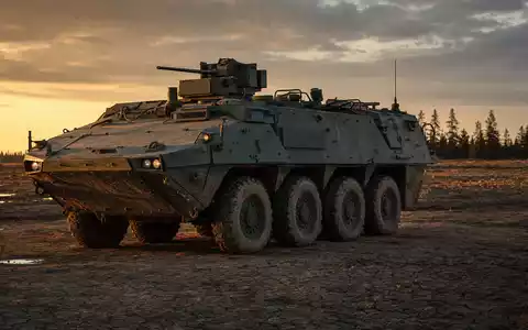 Rheinmetall AG (DE0007030009) zeigt einen gepanzerten Radpanzer im Dämmerlicht auf einem staubigen Truppenübungsplatz - Foto: THN