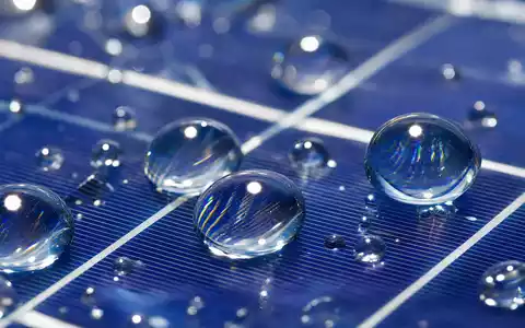 RWE AG (DE0007037129) Makroaufnahme eines Solarpanels mit feinen Wassertropfen auf glatter Oberfläche - Foto: THN