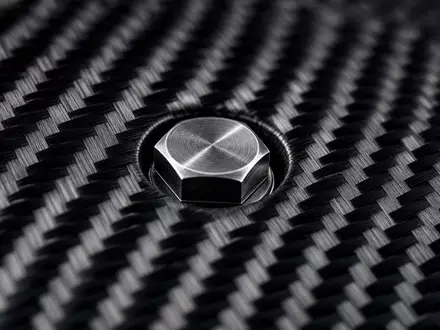 Porsche AG DE000PAG9113 Leichtbau: Makro Detail von Karbonfaser Gewebe mit Schraubenkopf aus Metall - Foto: THN
