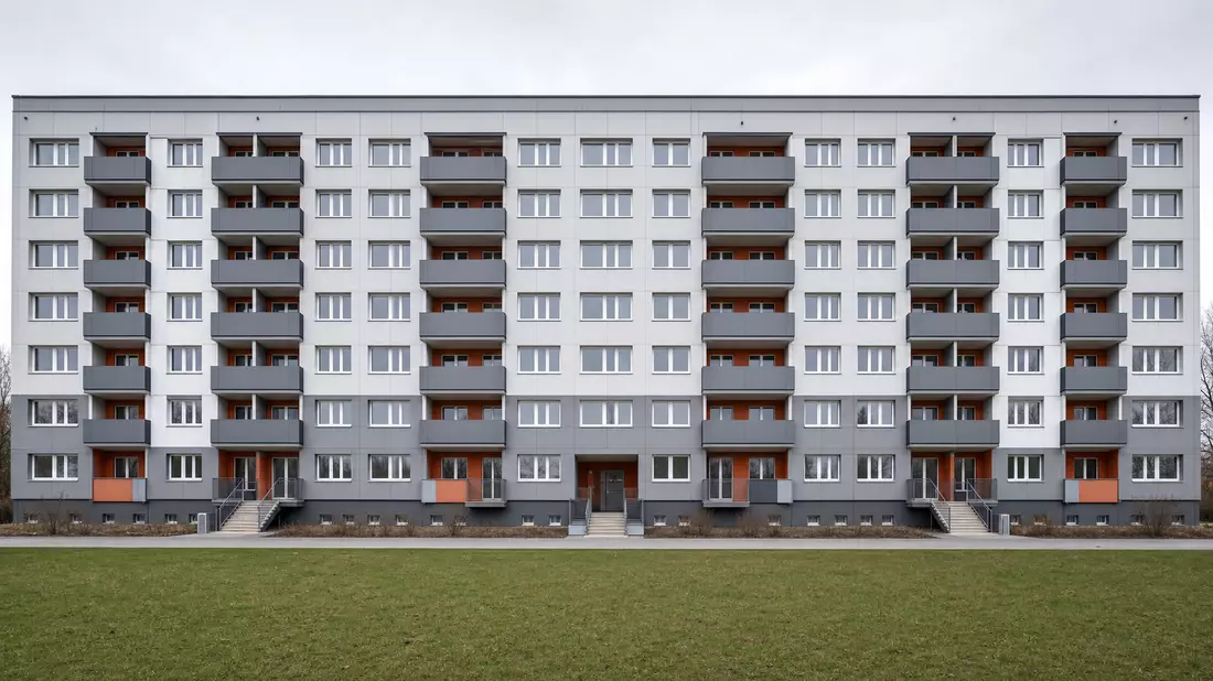 Modernisierter Plattenbau mit neuer Fassade, Terrakotta-Akzenten und Balkonen