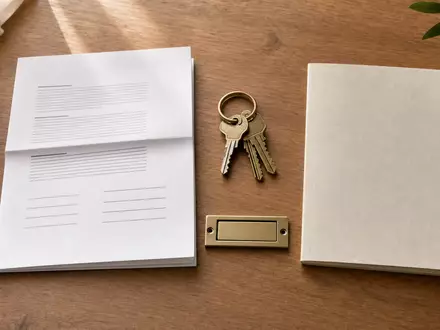 Vonovia SE DE000A1ML7J1 – Mietvertrag, Schlüsselbund, leeres Briefkastenschild und Energieausweis auf Holztisch - Foto: THN