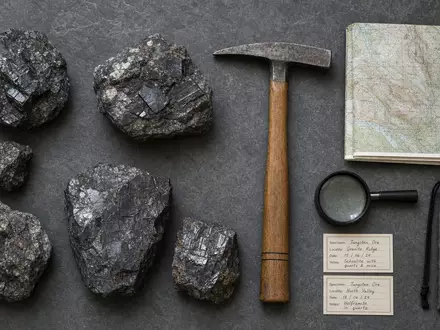 Almonty Industries Inc Wolframerz CA0203987072 als Flatlay mit Geologen-Hammer, Lupe und Geländekarte - Foto: THN