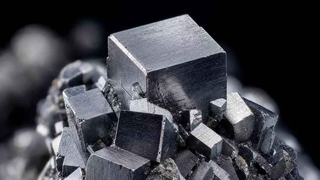 Extreme Makroaufnahme eines glänzenden Wolfram-Kristalls mit metallischem Schimmer und Bokeh