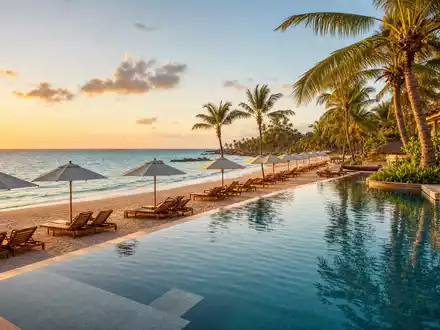 TUI AG (DE000TUAG505) zeigt ein tropisches Strand-Resort mit Liegen, Palmen und Pool bei Sonnenuntergang - Foto: THN