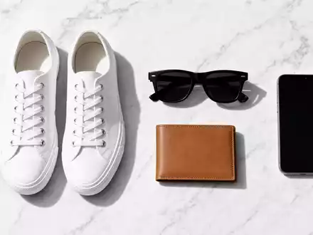 Zalando SE (DE000ZAL1111) – Flatlay mit Sneakers, Sonnenbrille, Geldbörse und Smartphone auf weißem Marmor - Foto: THN