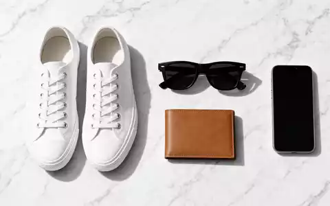 Zalando SE (DE000ZAL1111) – Flatlay mit Sneakers, Sonnenbrille, Geldbörse und Smartphone auf weißem Marmor - Foto: THN