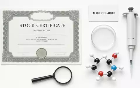 Flatlay-Arrangement mit Aktienzertifikat und ISIN-Karte DE0005664809 visualisiert die Aktie von Evotec SE als Biotech-Investment - Foto: THN