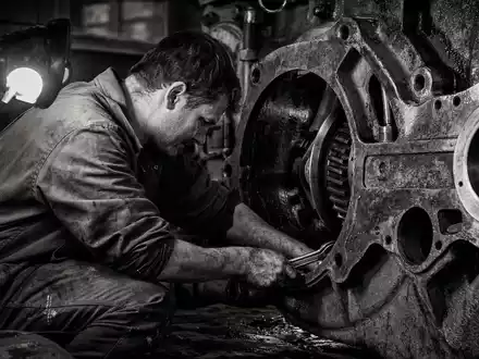 RENK Group AG DE000RENK730 – Dokumentarfoto eines Mechanikers beim Arbeiten an einem massiven Getriebe-Gehäuse - Foto: THN