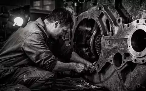 RENK Group AG DE000RENK730 – Dokumentarfoto eines Mechanikers beim Arbeiten an einem massiven Getriebe-Gehäuse - Foto: THN