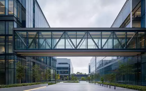 PayPal Holdings Inc (US70450Y1038) symbolisiert modernen Tech-Campus mit gläserner Verbindungsbrücke und klaren Linien. - Foto: THN