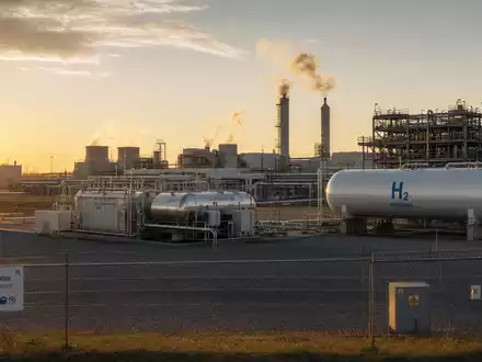Plug Power Inc US72919P2020 betreibt industrielle Elektrolyseur-Anlage mit Wasserstoff-Tanks und Rohren bei Sonnenaufgang - Foto: THN