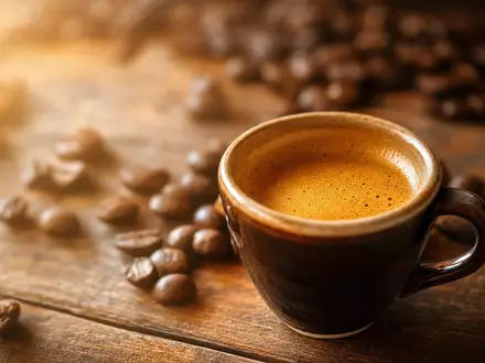 Nestlé S.A. CH0038863350 – warm beleuchtete Espressotasse mit goldener Crema auf rustikalem Holztisch - Foto: THN