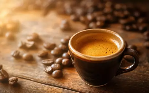 Nestlé S.A. CH0038863350 – warm beleuchtete Espressotasse mit goldener Crema auf rustikalem Holztisch - Foto: THN