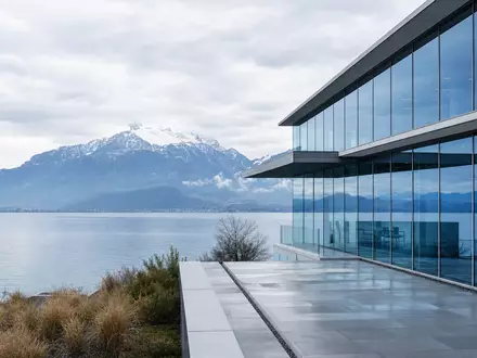 Nestlé S.A. CH0038863350 – moderner Glaskonzernbau am Genfersee mit klaren Linien und Alpenblick - Foto: THN