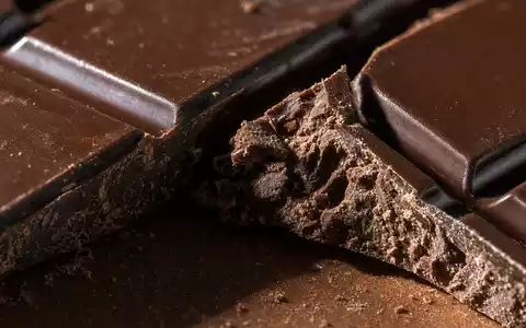 Nestlé S.A. CH0038863350 – extreme Makronahaufnahme einer gebrochenen dunklen Schokoladentafel mit scharfer Bruchkante - Foto: THN