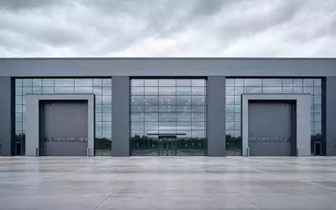 BYD Company Ltd (CNE100000296) – kubische Glas-Stahl-Fabrikfassade mit großen Hallentoren in klarer Architekturphotographie. - Foto: THN