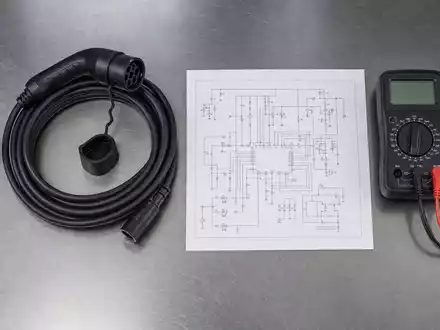BYD Company Ltd (CNE100000296) – Flatlay mit Batteriezelle, Ladekabel, Multimeter und Schaltplan auf Stahltisch - Foto: THN