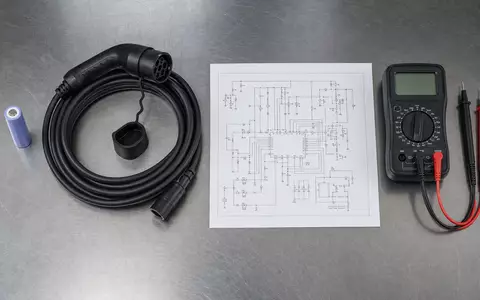 BYD Company Ltd (CNE100000296) – Flatlay mit Batteriezelle, Ladekabel, Multimeter und Schaltplan auf Stahltisch - Foto: THN
