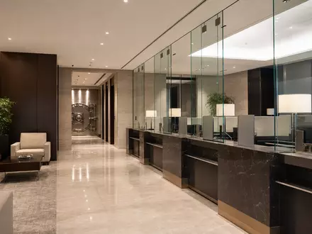 UBS Group AG CH0244767585 zeigt einen modernen Bankschalterbereich mit eleganten Glaspartitionen und massiver Stahl-Tresortür - Foto: THN