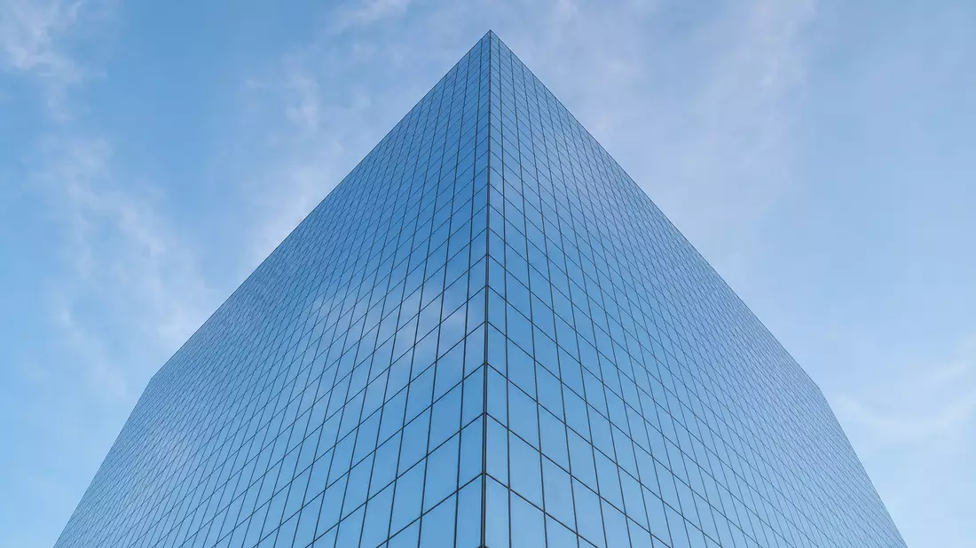 Kubisches Hochhaus aus Glas und Stahl, Froschperspektive, strahlend blau