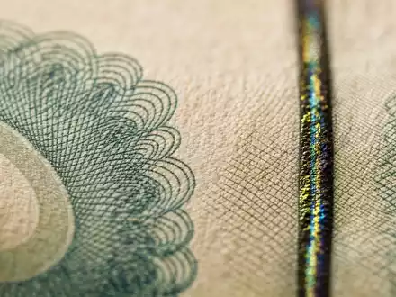 UBS Group AG CH0244767585 zeigt extreme Makro-Nahaufnahme einer Banknoten-Textur mit schimmerndem Sicherheitsfaden - Foto: THN