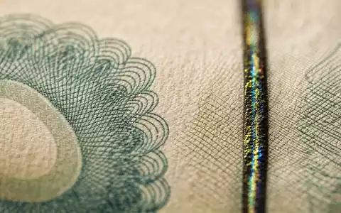 UBS Group AG CH0244767585 zeigt extreme Makro-Nahaufnahme einer Banknoten-Textur mit schimmerndem Sicherheitsfaden - Foto: THN