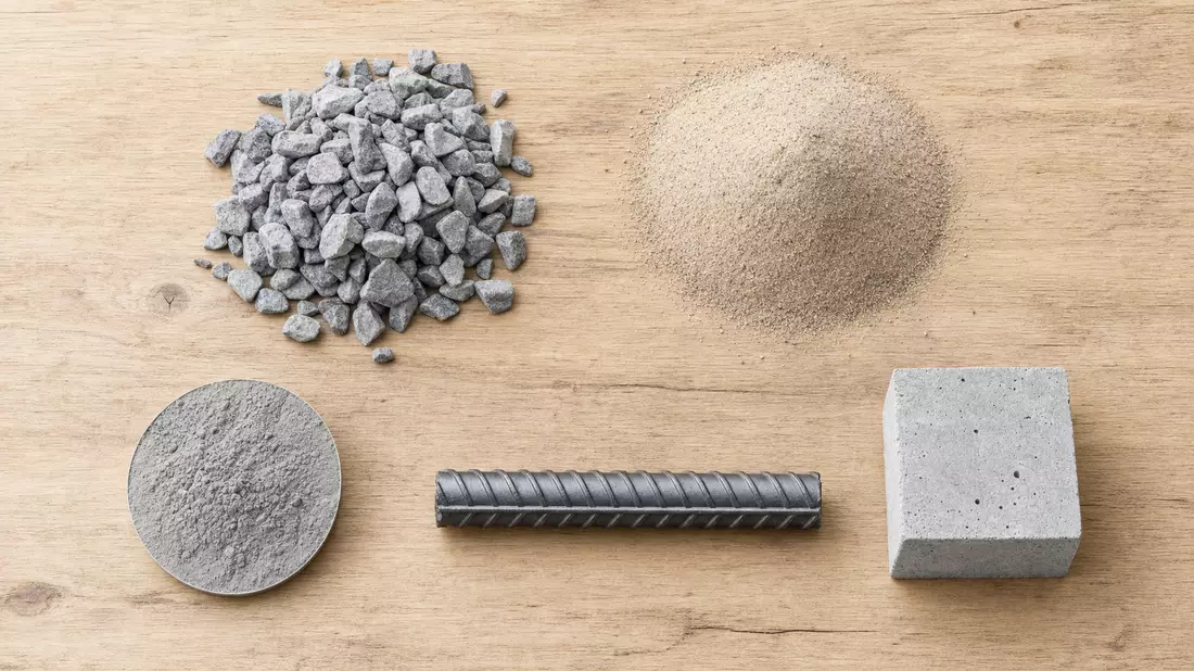 Sauber arrangiertes Flatlay-Foto auf hellem Eichenholzbrett. Von links nach rechts: ein Haufen graue