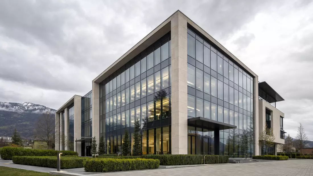 Modernes Wealth-Management-Bürogebäude mit Glasfassade und Natursteinverkleidung. Klare geometrische