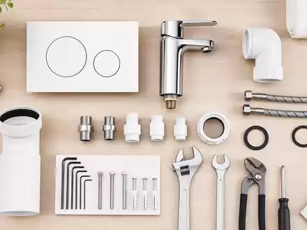 Geberit (CH0030170408) Sanitär-Komponenten als Flatlay: Spülsystem, Drückerplatte, Armaturen und Werkzeug auf Holz - Foto: THN