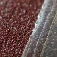 Makroaufnahme von Schleifpapierkörnern und Klebefolie veranschaulicht Materialien von 3M Company, ISIN US88579Y1010, Industriesparte - Foto: THN