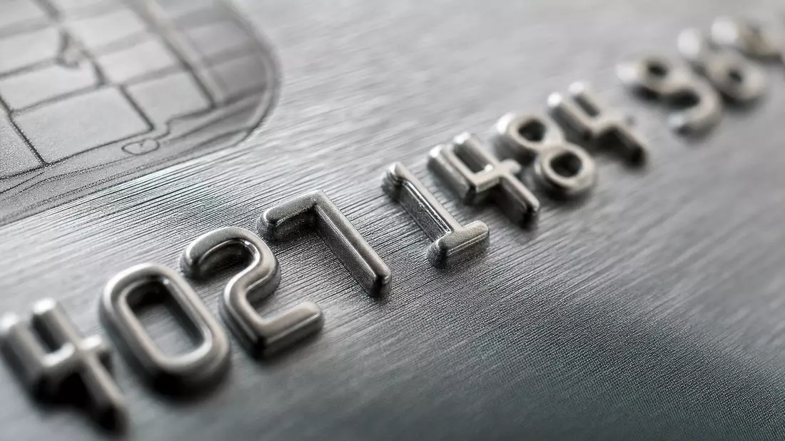 Makroaufnahme geprägter Ziffern auf einer grauen metallischen Kreditkarte