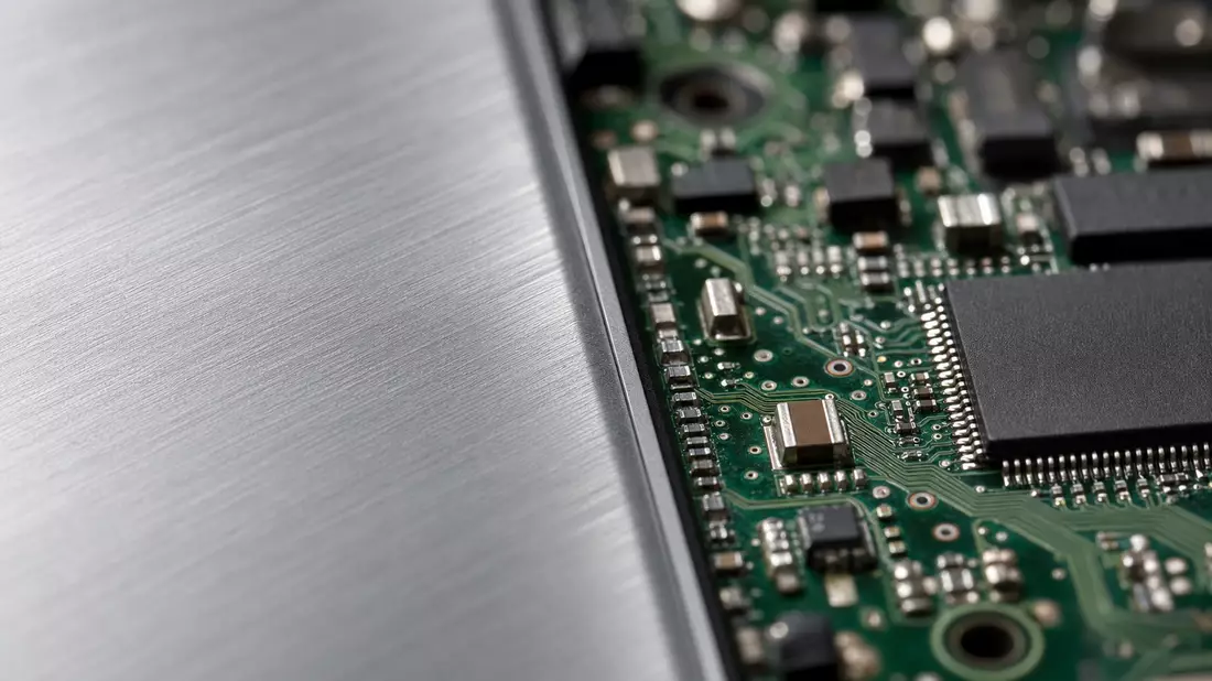 Makrofoto einer gebürsteten Aluminiumoberfläche neben einer elektronischen Platine
