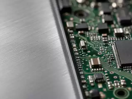 Makroaufnahme zeigt Detailstruktur einer Aluminium-Oberfläche und Platine für Apple Inc., ISIN US0378331005, in hoher Vergrößerung - Foto: THN