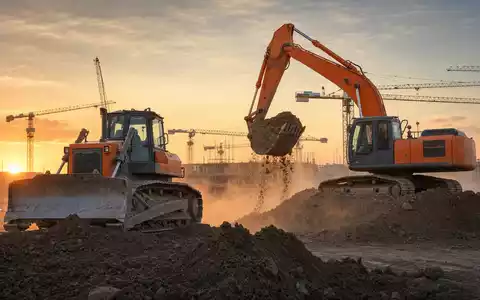 Fotorealistisches Baustellenbild passend zu Caterpillar Inc. (ISIN US1491231015), Bulldozer und Bagger bei Sonnenuntergang - Foto: THN