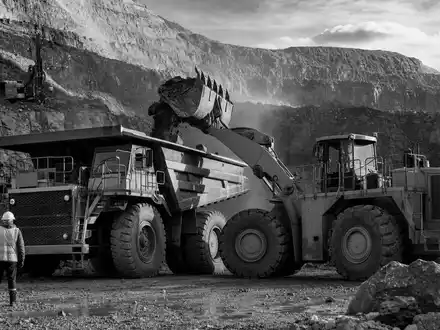 Dokumentarische Schwarzweiß-Reportage zu Caterpillar Inc. (ISIN US1491231015), Bergbau-Kipper im Tagebau mit Arbeitern - Foto: THN
